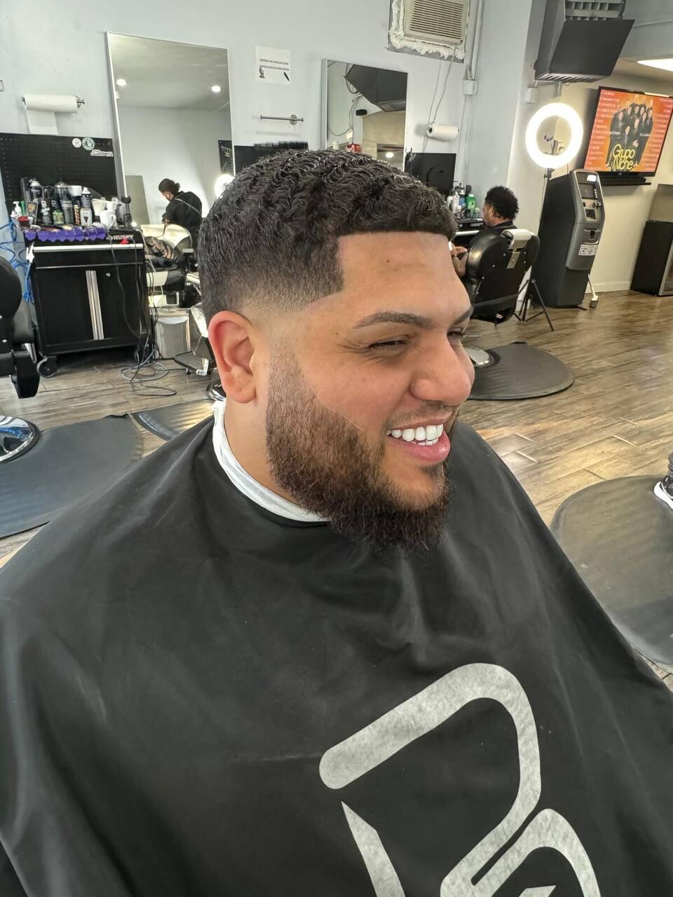 Curly top with low fade and full beard